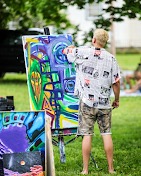 Jeffrey L'Esperance painting a colorful abstract canvas at an outdoor easel